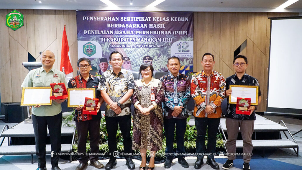 Cover Berita Samarinda – Mewakili Bupati Mahakam Ulu (Mahulu), Angela Idang Belawan, Asisten Administrasi Umum (Asisten III), Kristina Tening, S.H., M.Si., menyerahkan Sertifikat Kelas Kebun Berdasarkan Hasil Penilaian Usaha Perkebunan (PUP) di Kabupaten Mahulu sebagai instrumen evaluasi kinerja perusahaan perkebunan kelapa sawit yang beroperasi di wilayah Kabupaten Mahulu, dilaksanakan di Ruang Classical Lt.3 Hotel Ibis Samarinda. Kamis (27/11/25)